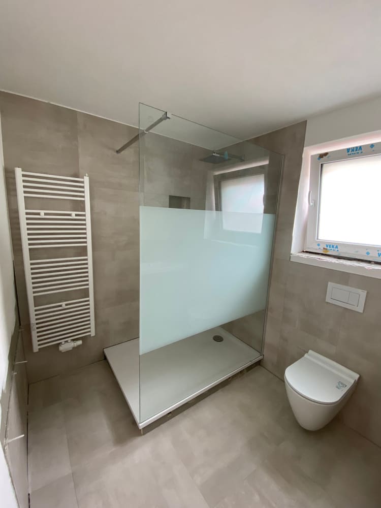 Dusche mit Glasabtrennung und Handtuchheizkörper