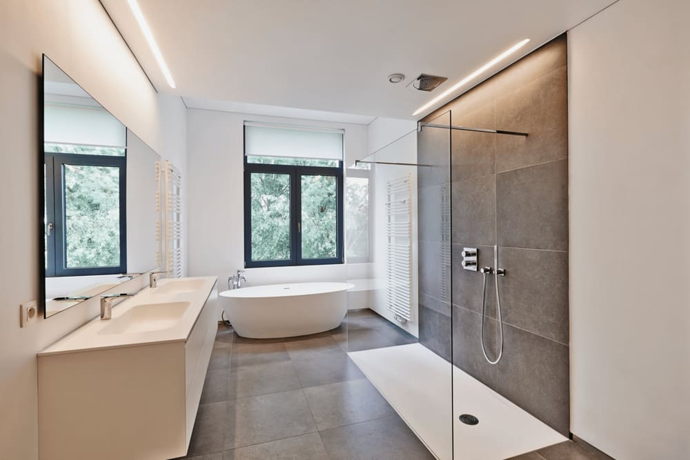 Helles, modernes Bad mit Badewanne, bodengleicher Dusche und Waschtisch
