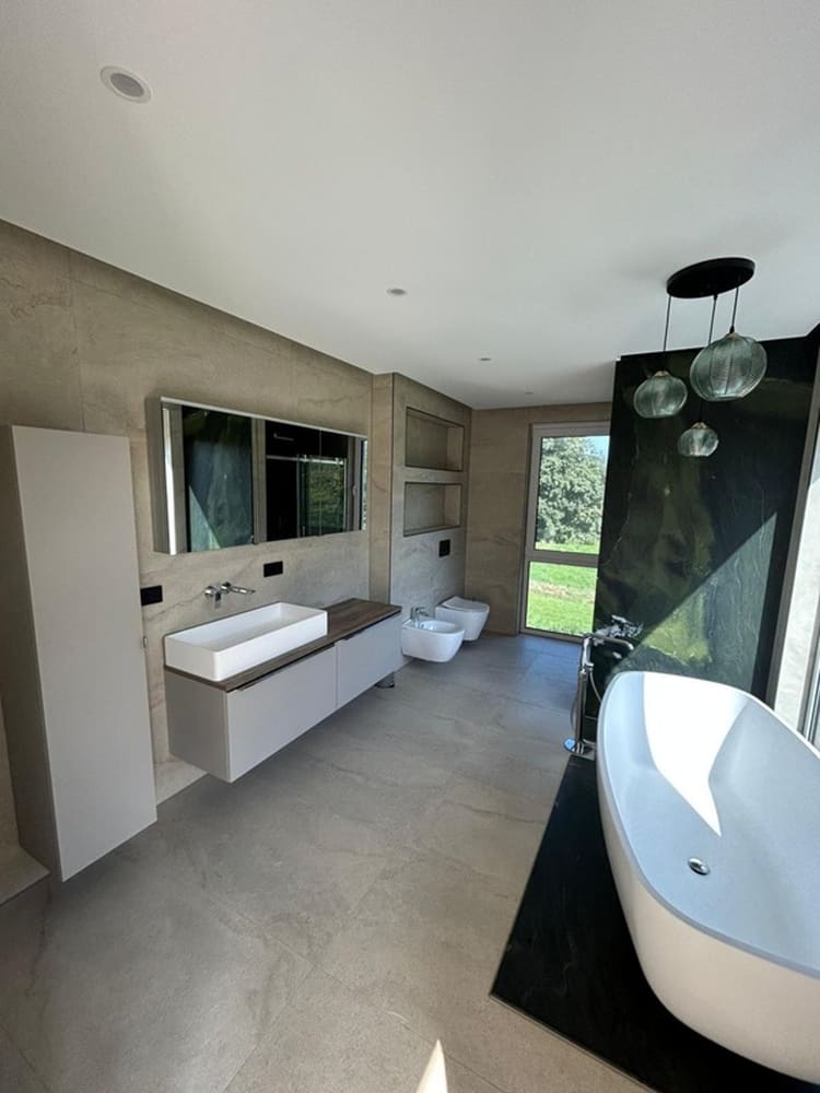 Freistehende Badewanne vor dunkler Wand