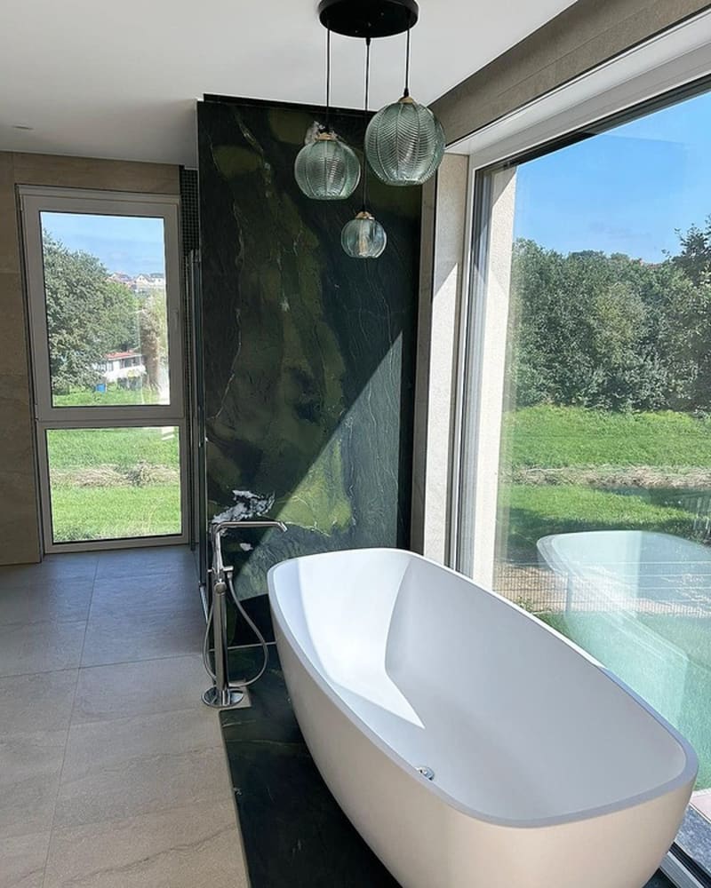 Freistehende Badewanne vor einem Fenster